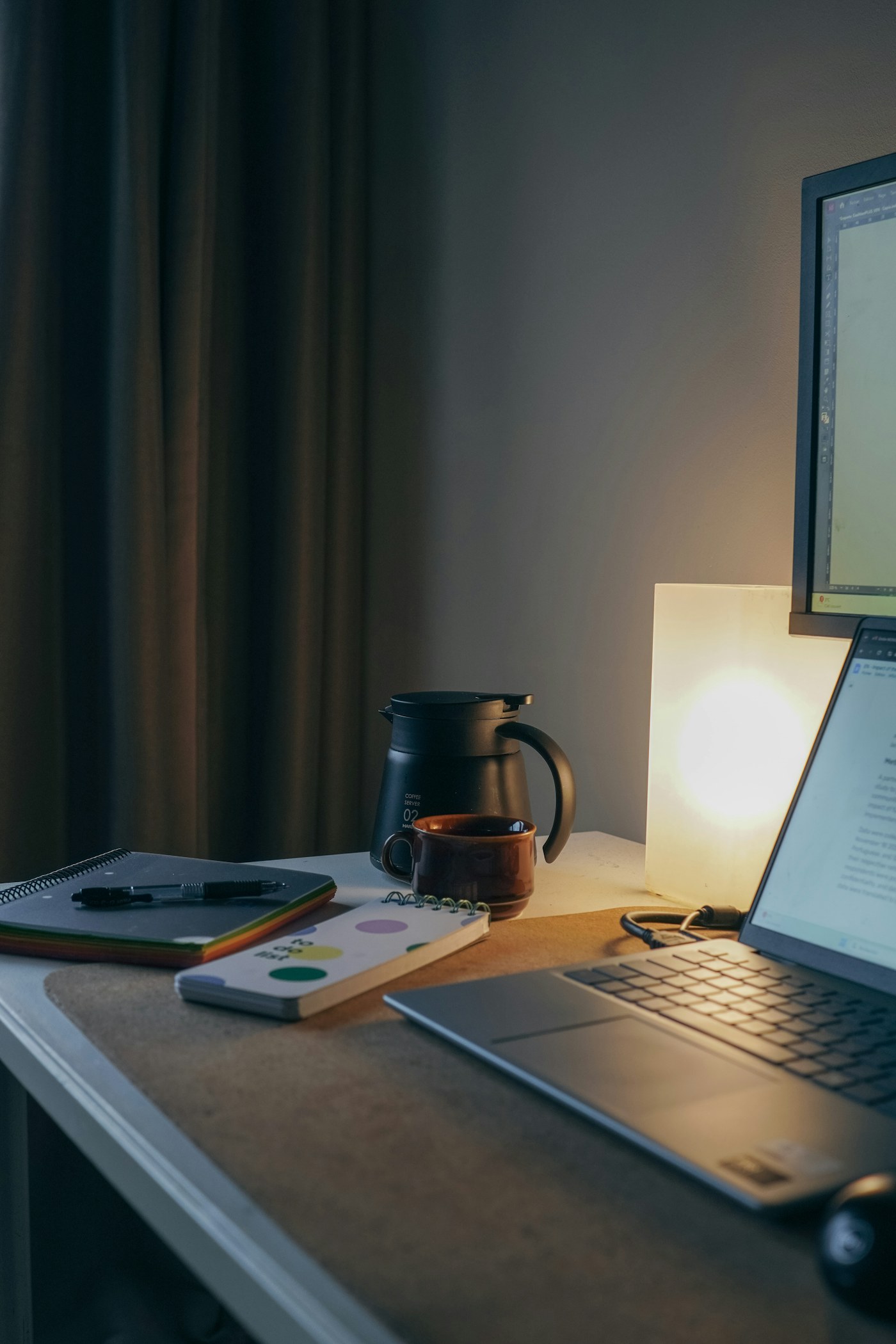 A calm workspace with a laptop, notebook, pen, and coffee.
